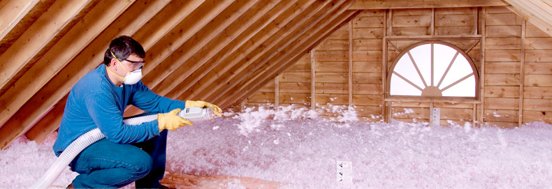 worker installs attic insulation