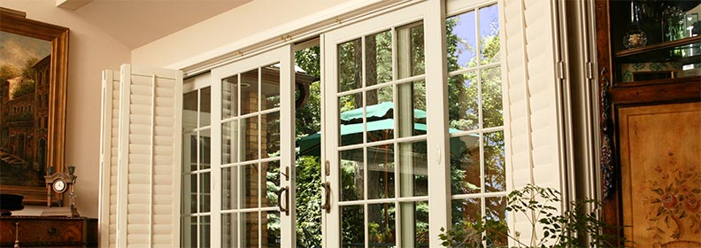 French sliding patio doors with white grilles open to outdoor patio