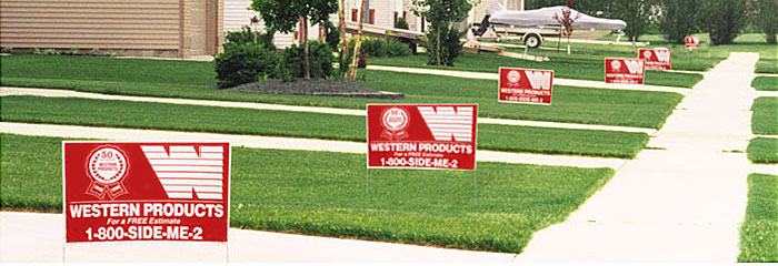 series of Western Products signs in the green lawns of homes on the same block