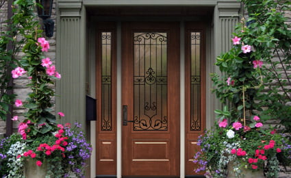 ProViaDoors_Signet_425x260 brown ProVia door with multiple decorative windows on stone house with flowering vines