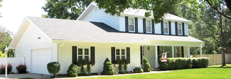 home exterior featuring white energy-efficient siding and gray roofing