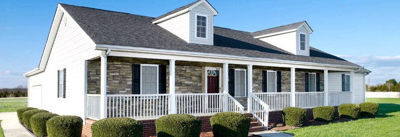 home exterior featuring tan ledgestone Versetta stone siding with white siding and trim to contrast