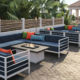 allure modular seating with blue cushions and white frames surround fire tables in outdoor area