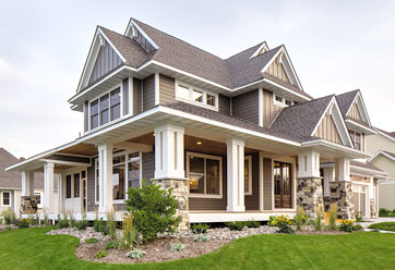 home exterior featuring tan LP SmartSide siding in both horizontal and decorative vertical patterns with white trim