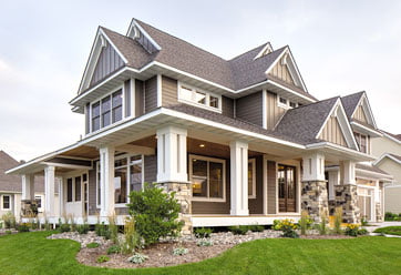 home exterior featuring tan LP SmartSide siding in both horizontal and decorative vertical patterns with white trim