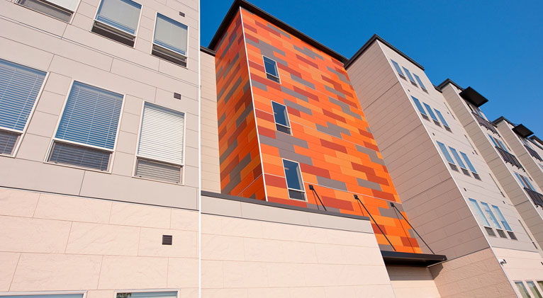 apartment exterior featuring nichiha fiber cement siding contrasted with bright tiles