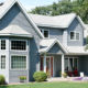 gray home exterior with seamless steel siding, light gray roofing, and surrounding trees