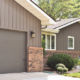 taupe home exterior with vertical seamless steel siding, color-matched roofing, and accent brick detailing