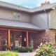 taupe home exterior with seamless steel siding, gray roofing, and brick accenting