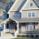 light taupe home exterior with seamless steel siding, gray roofing, white detailing, and grand architecture