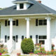 white home exterior with seamless steel siding, gray roofing, and pillars