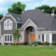 dark gray home exterior with seamless steel siding, matching roof, cobblestone accents, and grand architecture