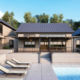 taupe home exterior with vertical seamless steel siding, dark gray roofing, and modern backyard pool