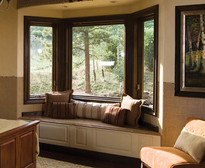 home interior bedroom with bay windows creating a seating nook with pillows