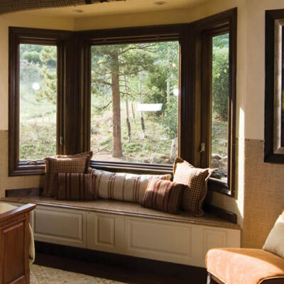 home interior bedroom with bay windows creating a seating nook with pillows