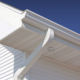 white soffit with vents and fascia finish a home with white siding and white gutters