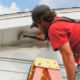 Western Products worker installing white soffit