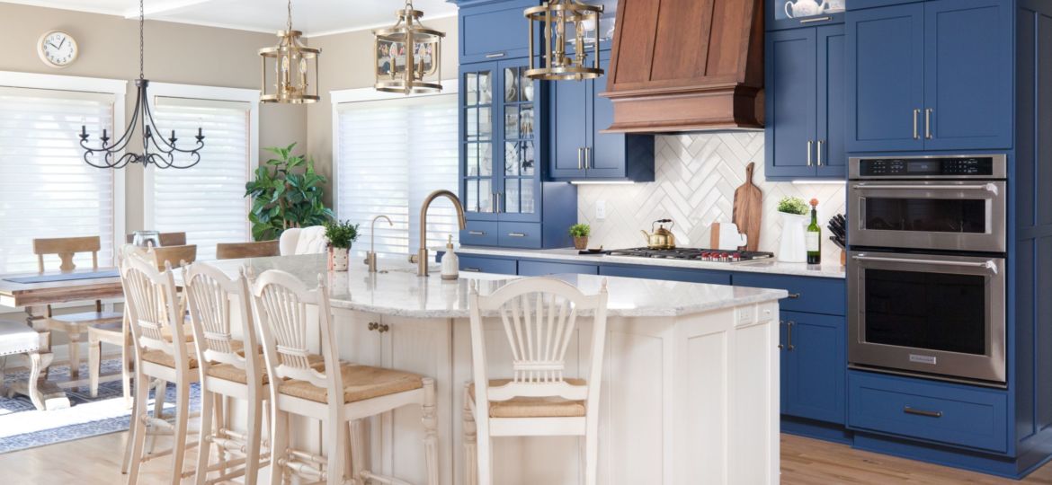 navy blue painted cabinets in a bright kitchen with a white island and bar stools