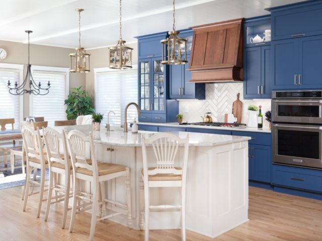 navy blue painted cabinets in a bright kitchen with a white island and bar stools